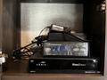 A 2021 Grand Design Recreational 311BHS featuring a compact entertainment system with a WiFi device and cable receiver stacked on a shelf