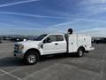 A 2017 Ford F-350 SD truck with a white service body and a red emergency light mounted on the roof