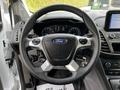 Steering wheel of a 2019 Ford Transit Connect featuring the Ford logo and various control buttons in a modern vehicle interior design