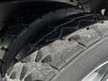 Two large, rugged tires from a 2010 Freightliner M2 106 with a deep tread pattern showing wear and dirt accumulation