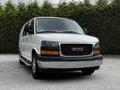 A 2023 GMC Savana van with a white exterior and chrome front grille featuring the GMC logo