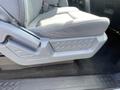 A close-up of the seat and console area in a 2012 Ford F-150 showing gray fabric upholstery and textured plastic trim features
