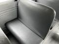 A black vinyl bus seat in a 2015 Spartan school bus with a rectangular cushion and a smooth surface
