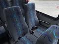 Interior seating of a 2020 Chevrolet Express van featuring grey fabric with blue and teal wave patterns and seat belts attached to the seats