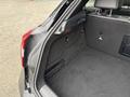 The image shows the trunk space of a 2016 Mercedes-Benz GLA-250 featuring a black carpeted interior with a netted storage area on one side and a flat surface
