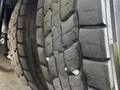 Close-up view of a worn tire with deep treads and embedded gravel stones on a Blue Bird BB Conventional bus
