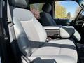 The interior of a 2016 Ford F-550 showing two front seats with fabric upholstery and a center console between them