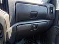 Interior view of a 2021 Chevrolet Silverado 1500 showing a textured black dashboard with a storage compartment and a button for features like locking or unlocking storage