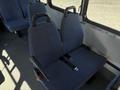 Blue upholstered bus seats with safety harnesses in a 2017 Chevrolet Express interior