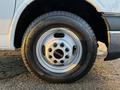 Close-up of a 2015 GMC Savana wheel featuring a silver rim with six holes and a black tire labeled Michelin