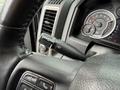 Close-up of the steering wheel and controls in a 2018 RAM 1500 showing the turn signal lever and dashboard instruments