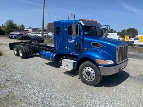 A blue 2008 Peterbilt 340 truck with a streamlined design and chrome accents, featuring a cab with orange lights and a large front grille