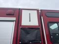 A red fire truck with a diamond plate panel and a black canvas flap attached to the side