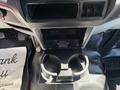 A black cup holder insert inside the center console of a 2014 Ford F-250 SD with a small compartment above it