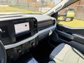 Interior view of a 2023 Ford F-550 showcasing the dashboard with a touchscreen display and controls next to a gray upholstered driver's seat