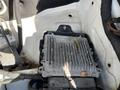 The image shows a 2010 Mercedes-Benz Sprinter engine compartment with a silver electronic control unit prominently displayed and some debris on top