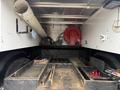 A 2016 RAM 1500 truck bed showing various tools and equipment including a red hose reel and storage compartments