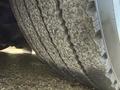 Close-up of a worn tire showcasing significant tread wear and dirt accumulation on the surface