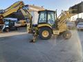 A yellow 2007 Komatsu WB156PS-5 backhoe loader with a front loader bucket and rear excavator arm parked on a paved surface