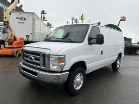 A 2011 Ford Econoline van in white with a silver grille and wheels parked with its side facing the viewer