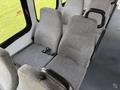 Two gray fabric seats in a vehicle interior with seat belts visible