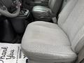 A gray upholstered driver's seat of a 2009 Chevrolet Express van with black plastic console and floor mat visible