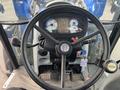 The interior of a 2016 New Holland T475 tractor featuring a circular steering wheel dashboard with various gauges and controls