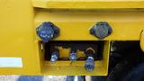 Close-up of a yellow 2009 International 7400 truck's rear control panel featuring several valves and connectors