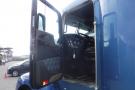 A blue 2015 Kenworth T660 semi-truck with an open door revealing the driver's seat and dashboard inside