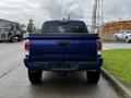 A blue 2022 Toyota Tacoma viewed from the rear with a black bed and license plate area visible