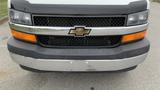 Front view of a 2017 Chevrolet Express Quigley 4x4 with a black and chrome grille featuring a gold Chevrolet logo and orange headlights