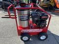 A red Magnum 4000 Hot Water Pressure Washer featuring a large cylindrical tank, a gas engine, and two sturdy wheels for mobility