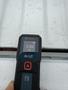 A Bosch laser distance measurer displaying a measurement of 8.460 ft against the surface of a 2013 Chevrolet Silverado 3500HD