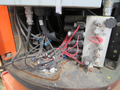 A close-up view of the wiring and control panel of a 2009 JLG E300AJP with numerous wires and connectors visible in a cluttered arrangement