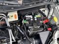 A close-up view of the engine compartment of a 2013 Ford Transit Connect highlighting the battery and various electrical components