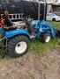 A 2021 LS XJ2025H tractor in blue color with large black tires and a front loader attachment
