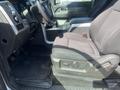 Interior view of a 2014 Ford F-150 highlighting the driver's seat and dashboard with controls and console visible