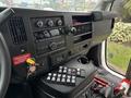 The interior dashboard of a 2020 Chevrolet Express featuring controls for audio and climate, a gear shift, and a panel with various buttons and switches