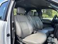 The interior of a 2016 Ford F-150 featuring gray leather seating for five with adjustable headrests and armrests