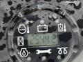 Close-up of a control panel displaying reading of 2542 with various symbols for battery oil and temperature on a wet surface