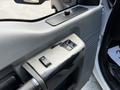 Close-up of the control panel of a 2016 Ford F-550 showing window switches and armrest with visible wear on the surface