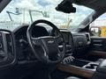 Interior view of a 2017 Chevrolet Silverado 1500 featuring a black leather steering wheel and dashboard with a touchscreen display and wooden accents