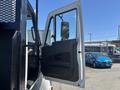 A 2018 International DuraStar truck with the driver's side door open showcasing the interior cabin and mirror