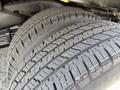 Close-up of a 2023 Ford E-450 tire displaying deep tread patterns and grooves designed for traction and stability
