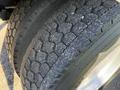 Close-up of a worn tire from a 2011 Freightliner M2 106 showing visible tread wear and small indentations on the rubber surface