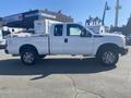 A white 2014 Ford F-250 Super Duty truck with four doors and alloy wheels parked on a lot
