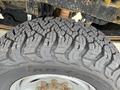 Close-up of a rugged tire with deep treads mounted on a wheel from a 2017 Ford F-250 SD
