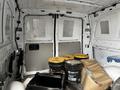 A 2018 Mercedes-Benz Metris van interior showing the cargo area with yellow-lidded buckets and cardboard boxes