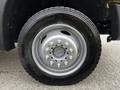 A close-up view of a wheel from a 2016 Ford F-550 featuring a silver rim and a rugged tire with visible tread patterns