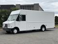 A 2018 Ford Econoline cargo van in white with a boxy design featuring large windows and a flat front end with a single windshield wiper